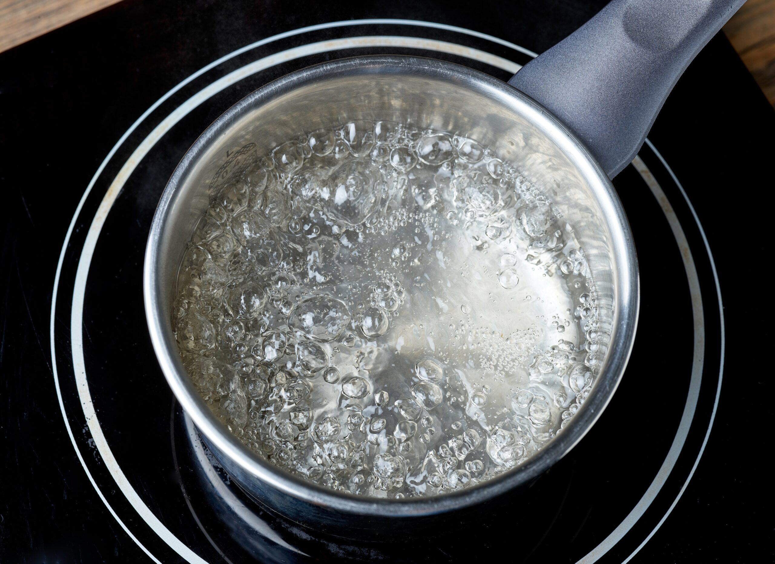 An aerial shot of a pot of boiling water on a stove.