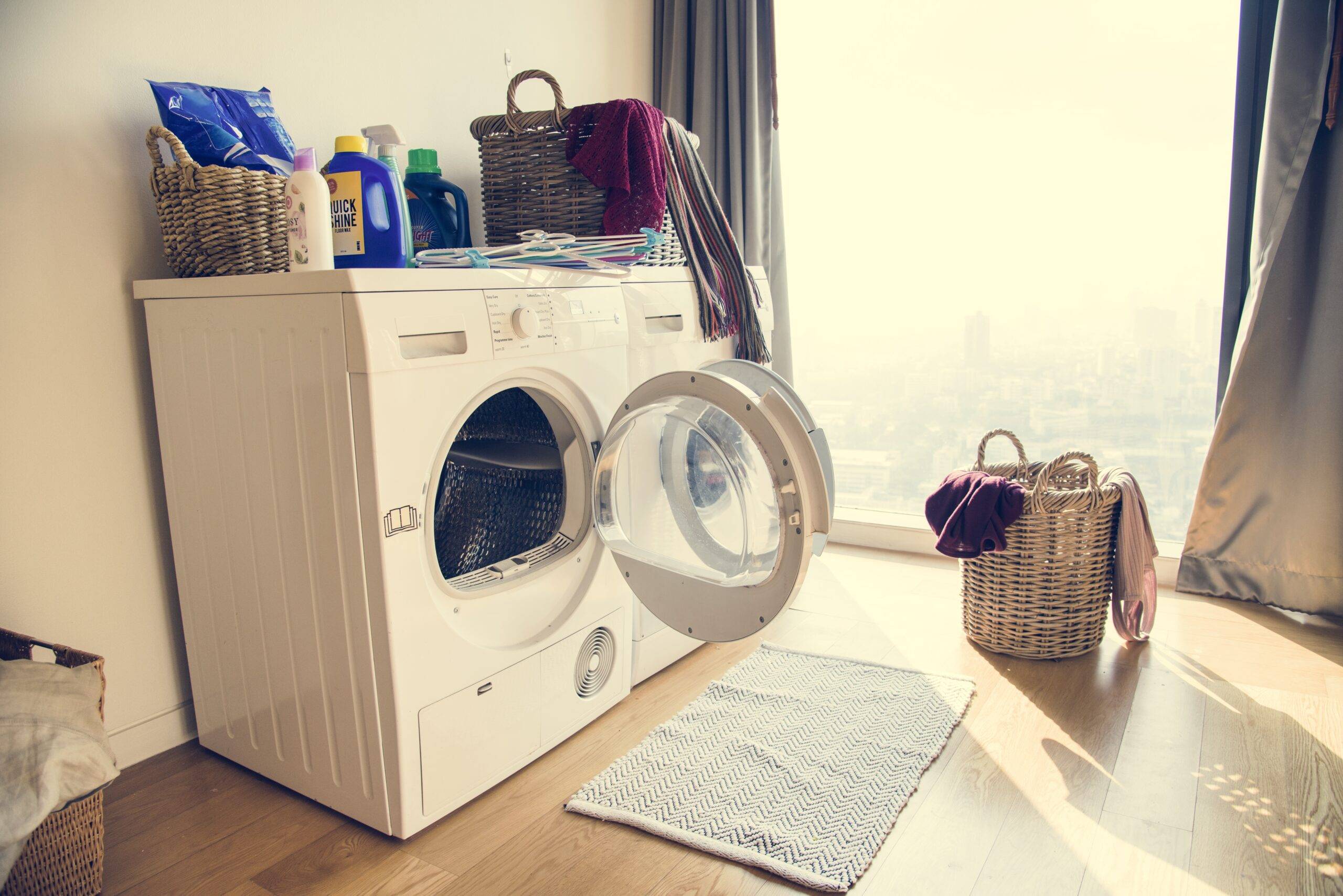A washer and dryer set next to a large window.