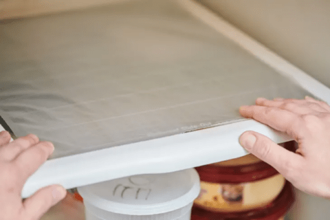 Plastic wrap lining fridge shelves.