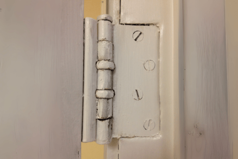 Door hinge painted white.