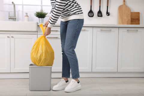 Taking out a trash bag from kitchen bin.