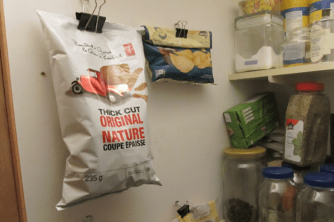 Two binder clips on wall holding chip bags.