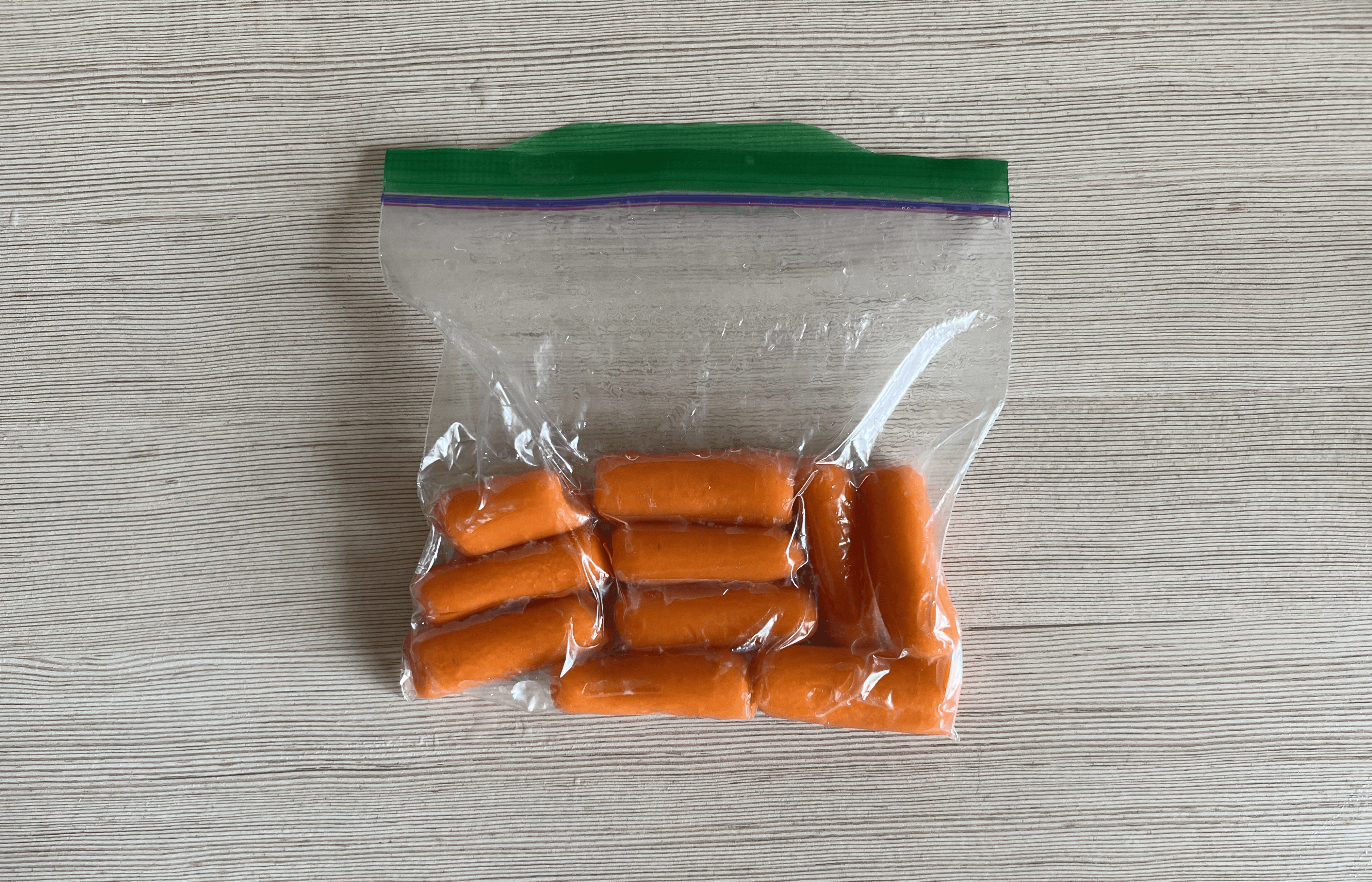 A ziploc bag of carrots, now vacuum sealed, on a table.