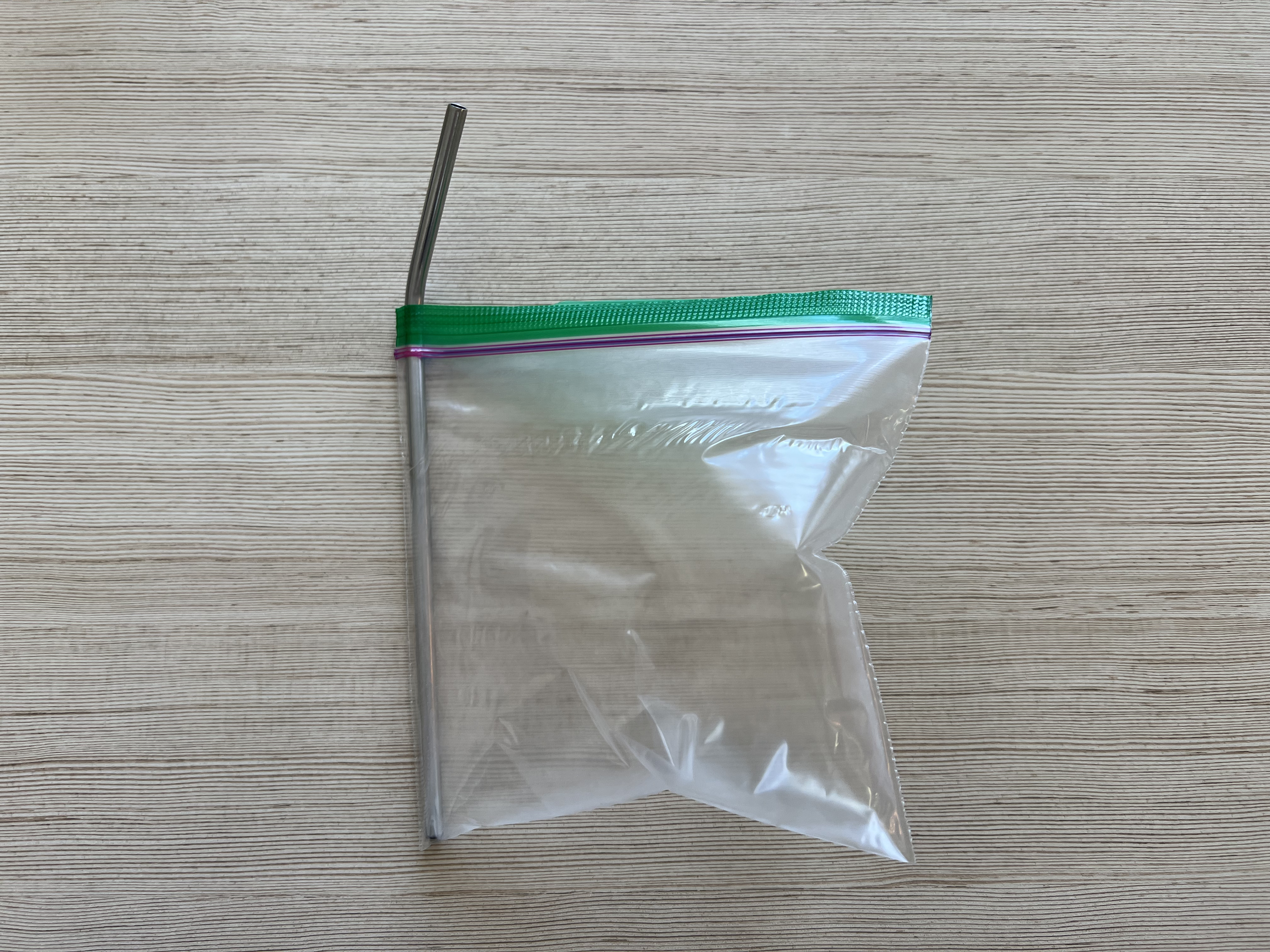 A ziplog bag, inflated, with a straw stuck in one side.